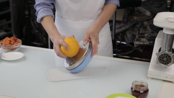Кондитер розрізає апельсинову шкірку, цитрусову цедру, очищає апельсинову шкірку — стокове відео