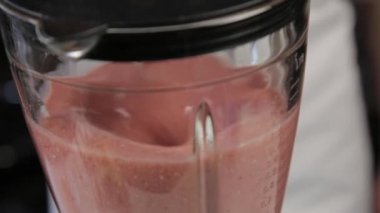 evde kadın pişirme, susam ile meyve meyvesi kokteyli, bir mikser karışımları malzemeyi yakın çekim. sağlıklı kahvaltı.