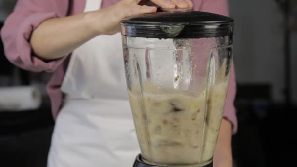 Frau kocht zu Hause, Bananenschokolade Shake. Zutaten in einem Mixer mischen. gesunde Ernährung — Stockvideo