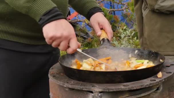 Cozinhar legumes com carne ao ar livre. legumes fritos em um caldeirão. conceito de férias. 4K — Vídeo de Stock