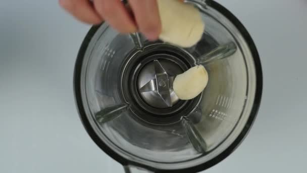 Mujer joven cocinando un cóctel de frutas y bayas en una licuadora. alimentación saludable, cocina, comida vegetariana, concepto de dieta. vista superior 4K — Vídeo de stock