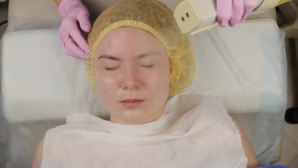 Doctor rengör kvinnans hud med en ånga. ung kvinna med problemhy på kosmetolog. Kosmetika koncept — Stockvideo