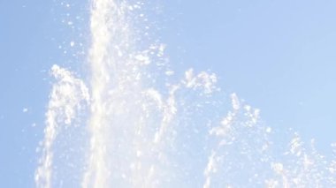 güneşli bir günde bir gökyüzü arka plan üzerinde çeşme su akıntıları. yavaş çekim