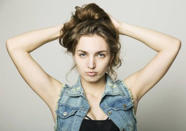 genç güzel mutlu şık hippi kız bir kot ceket ve hafif bir arka plan üzerinde poz şort