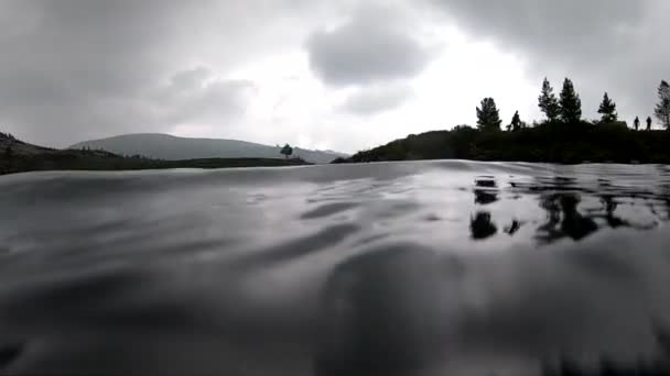 Buceadores exploración de un lago de montaña. cámara lenta. mal tiempo buceando, agua helada. instructor de buceo realizando un curso de buceo en aguas poco profundas — Vídeos de Stock