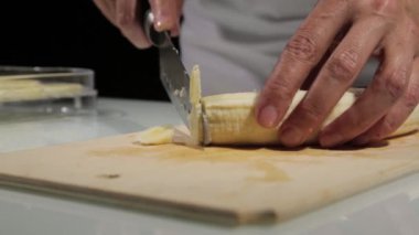 mutfak bıçak slayt kullanan kadınlar ahşap kesme tahtası üzerinde muz kesti. Kurutulmuş meyveler için muz dilimleme