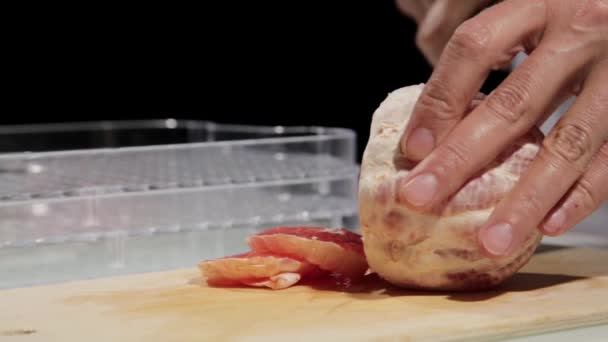 Donne che utilizzano coltello da cucina scivolo pompelmo tagliato su tagliere in legno. Pompelmo affettato per frutta secca — Video Stock