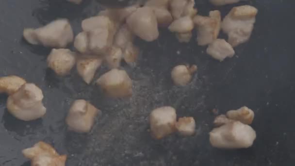 Praskání se rozmíchá ve velké pánvi. kousky masa v kusech se smažují v oleji. 4k — Stock video