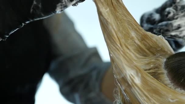 Hairdresser makes hairstyle, dye for a teenager in a beauty salon. Hair covered in dye. slow motion — Stock Video