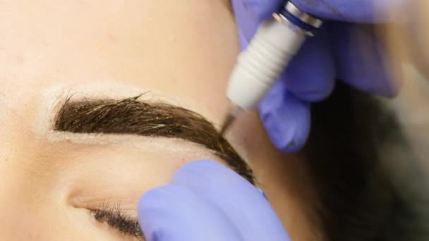 Les mains rapprochées du maître qui fait le tatouage des sourcils. maquillage permanent des sourcils. 4K — Video