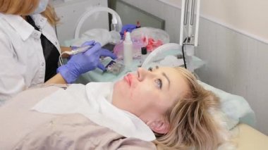 doktor kozmetolojist kadın müşteri dudakları için kalıcı makyaj prosedürü yapar. yavaş çekim