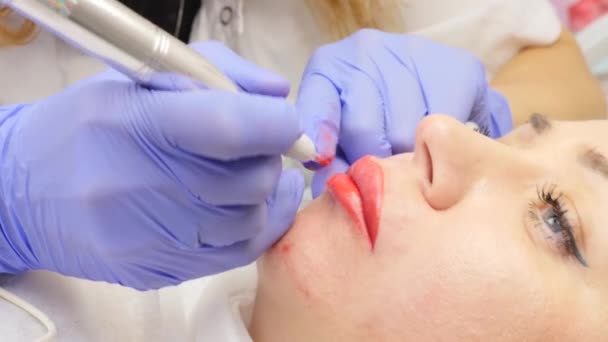 Doctor kosmetolog gör förfarandet för permanent makeup för kvinnliga klient läppar. Slow motion — Stockvideo