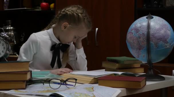 Schoolmeisje doet huiswerk, kleine blonde meisje studeren thuis aan de tafel. Childrens onderwijs. 4k — Stockvideo