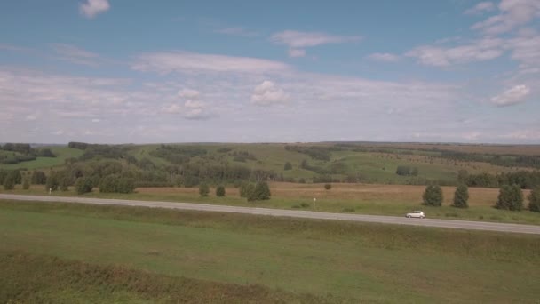 Luftaufnahme. landwirtschaftliches Feld nach der Ernte, Landstraße zwischen den Feldern. 4k — Stockvideo