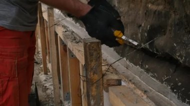 işçi ahşap kalıp, eski ev için yeni temel sökülür. işçi tel kesiciler ile metal tel keser