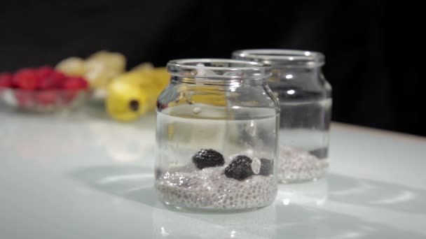 Kochen Pudding auf Kokosmilch mit Chia, Himbeeren, Bananen und Blaubeeren. gesundes Dessert und Diätkonzept — Stockvideo