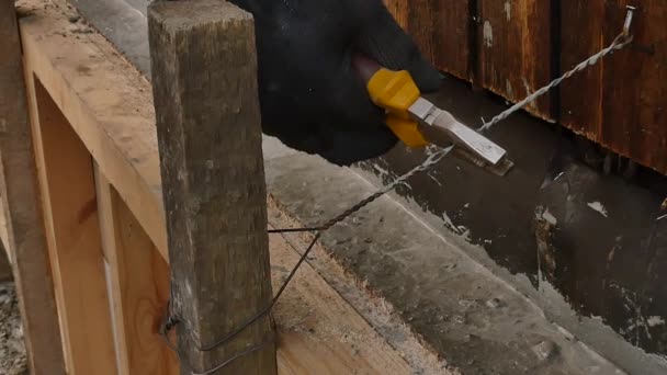 Werknemer ontmantelt de houten bekisting, nieuwe Stichting voor oud huis. werknemer snijdt de metaaldraad met draadfrezen — Stockvideo