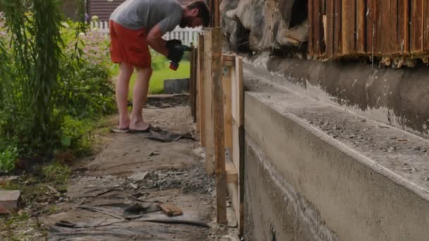 Arbeiter demontieren die Holzschalung, neues Fundament für altes Haus. 4k — Stockvideo