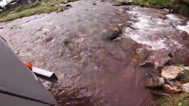 Med bil på väg. Bilen passerar vägen med stenar, pölar och lera. Av vägen reser på berg. — Stockvideo