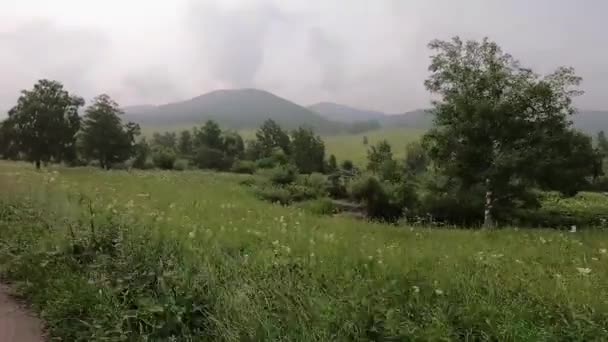 En coche fuera de la carretera. El coche pasa por el camino con piedras, charcos y barro. Fuera de la carretera viaje en la montaña . — Vídeos de Stock