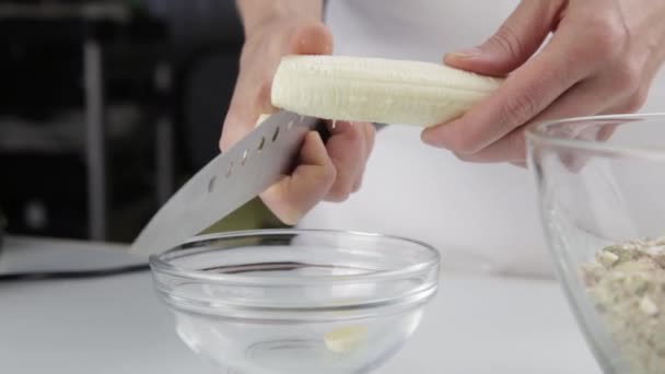 Γυναίκα που κόβει μια μπανάνα με μαχαίρι. κοπή μπανάνα κρατώντας ψηλά — Αρχείο Βίντεο