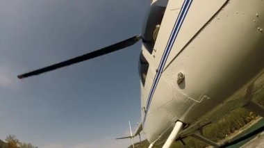 Helikopter dağlık bir bölgedeki bir nehir kıyısına iniyor. Küçük hafif havacılık. Bir pervanenin alt görünümü