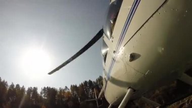 Helikopter dağlık bir bölgedeki bir nehir kıyısına iniyor. Küçük hafif havacılık. Bir pervanenin alt görünümü