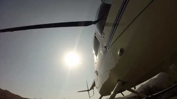 Helicóptero de vuelo bajo en las tierras altas. Pequeña aviación ligera. vista inferior de una pala de hélice — Vídeos de Stock