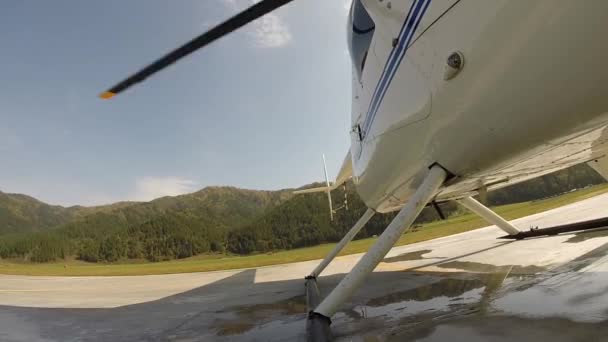 Взлет вертолета с вертолетной площадки в горной местности. низколетящий вертолет в высокогорье. Небольшая легкая авиация. вид снизу на лопасти пропеллера — стоковое видео