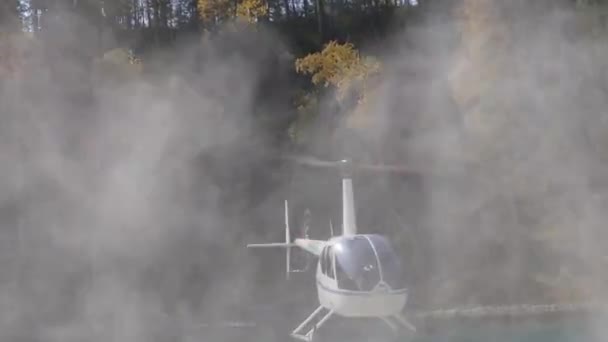 Vrtulník přistávající na břehu řeky v hornaté oblasti. nízko letící helikoptéra na vysočině. Malé lehké letectví — Stock video