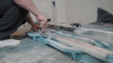Tadilat sırasında bir odaya fayans döşemek için fayans kesici araç kullanıyor