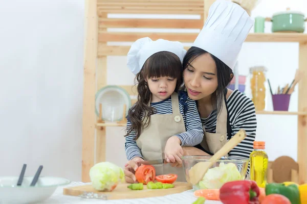 妈妈和孩子女孩在厨房做饭和切蔬菜 生活方式概念 — 图库照片