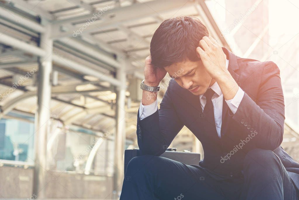 Young asian depressed businessman failed or upset in his job his sitting on staircase.  Business and Job Concept