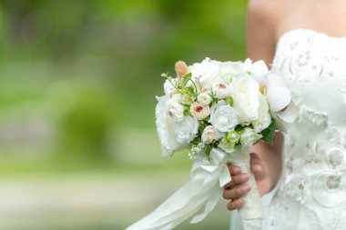 Gelin düğün buket tutar. Gelin beyaz gelinlik bahçede. Doğa arka plan.