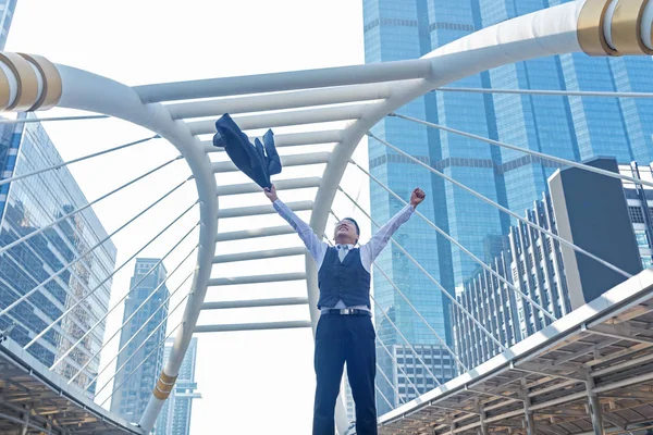 Başarı kutluyor. İşadamı kaldırdı ve ifade silah açık havada arka planda bina ofis ile ayakta iken pozitif tutmak. İş kavramı