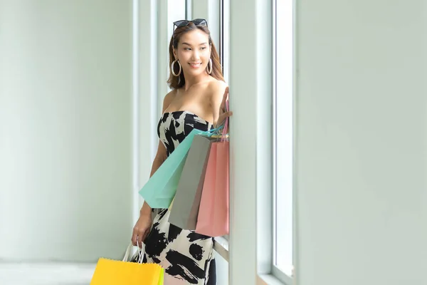 Asian smiling woman so happy shopping online with her shopping in casual clothing with shopping bags.  Lifestyle Concept