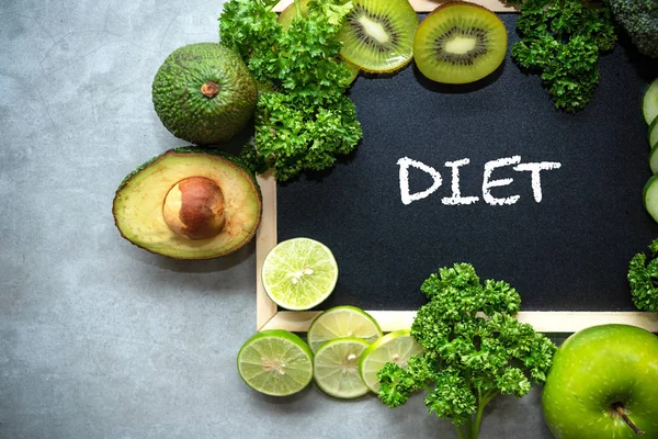 DIET chalk inscription on the board table.  Diet for the healthy body and detox with fresh green fruits  and vegetable.  Healthy Concept.