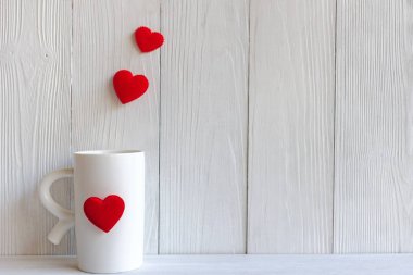 Sevgililer günü kenarlıklı kırmızı Kupası Kahve dikti yastık kalpler satır, ahşap beyaz arka plan, kopya alanı Sevgililer kavramı.
