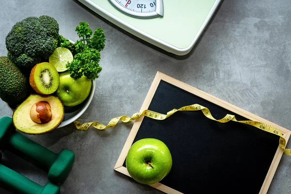 Diet and Healthy life loss weight Concept. Green apple and Weight scale measure tap with fresh vegetable and sport equipment for women diet slimming. Top view and copy space.