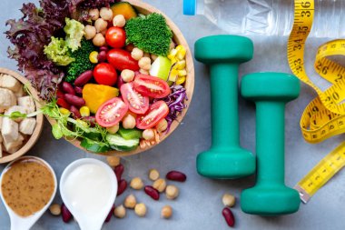 Taze sebze salatası ve sağlıklı gıda Spor donatımı için kadınlar için kilo kaybı için ölçü mekândaki siyah arka plan beton ile zayıflama diyet. Sağlıklı spor kavramı