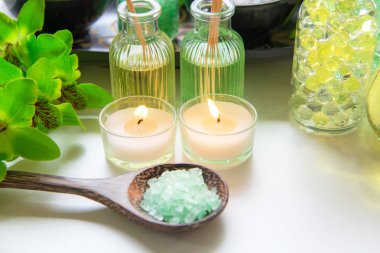Tay Spa uygulamaları aroma terapi tuz ve doğa yeşil şeker fırçalayın ve taş ahşap beyaz mum ile Yeşil orkide çiçek ile masaj. Tayland. Sağlıklı kavramı. kopyalama alanı, select ve yumuşak focu
