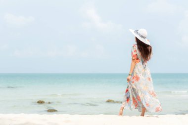 Yaz tatili. Lifestyle kadın kumlu okyanus plajında ayakta moda yaz gezileri giyiyor. Mutlu kadın zevk ve tatil dinlenmek. Yaşam tarzı ve seyahat konsepti