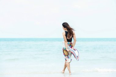 Yaz tatili. Büyük beyaz şapka tutan ve kum okyanus plaj yürüyüş moda yaz gezileri giyen yaşam tarzı kadın sakin ol. Mutlu kadın zevk ve tatil dinlenmek. Yaşam tarzı ve seyahat kavramı