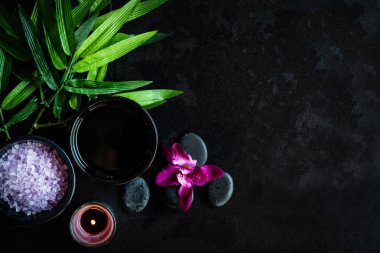Thai Spa. Üstten görünüm için ayarlama sıcak taş tedavi masaj ve mor orkide cins blackboard kopya alanı ile rahatlayın. Yeşil yaprak siyah taş yığını için spa terapi ile. Yaşam tarzı ve sağlıklı kavramı.