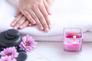 Kaplıca tedavisi ve ürün için kadın ayak ve manikür çivi spa relax ve dinlenme mum ışığı ve pembe çiçekli. Sağlıklı kavramı.