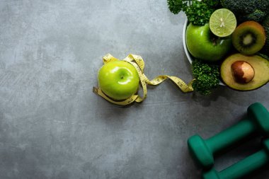 Diyet ve sağlıklı yaşam kaybı Ağırlık kavramı. Yeşil elma ve zayıflama diyet kilo ölçek ölçü tap taze sebze ve Spor donatımı ile kadınlar için. En iyi görünüm ve kopya alanı