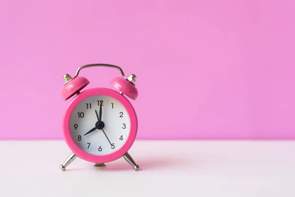 色の背景と床に落ちるアラームピンクのヴィンテージ目覚まし時計 朝とスタートアップのコンセプト — ストック写真