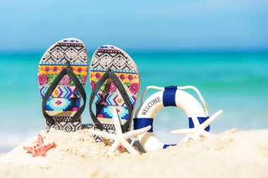 Deniz yıldızı kumlu plajı ile kum plaj sandalet kapatın. Yaz ve tatil kavramı