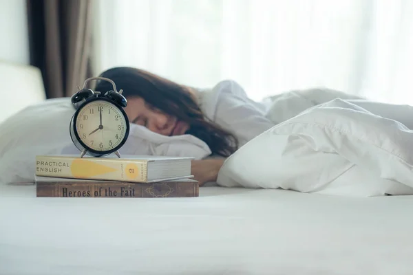 Early Work day. Close up Alarm vintage clock with women sleep the bed in morning.  Lifestyle Concep