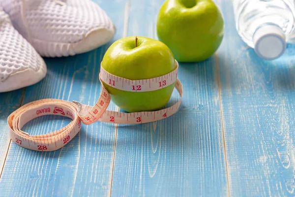 Diet and Healthy life loss weight Concept. Green apple and Weight scale measure tap with fresh vegetable and sport equipment for women diet slimming. Top view and copy space